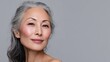 © Johannes - senior older middle aged asian woman with grey hair and radiant face with perfect skin advertising of rejuvenating skincare and makeup for natural radiant glow and healthy skin copy space no logos no