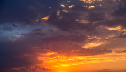 Wall Mural - Bright orange sunset sky background with dramatic clouds.