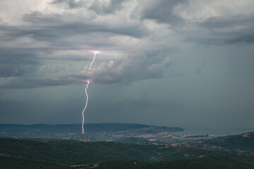 Wall Mural - dramatic lightning strike in a coastal city under stormy skies over gulf of trieste, italy