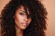 © Popelniushka - Radiant Beauty: Close-Up Portrait of a Black Woman with Lush Curly Hair Against a Soft Peach Background