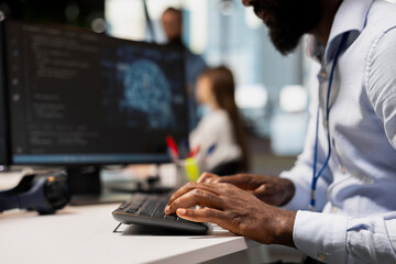 Close up of engineer typing on PC keyboard, coding with AI language model assistance. IT expert writing code, doing software development using artificial intelligence LLM assistant suggestions
