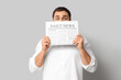 © Pixel-Shot - Shocked young man with newspaper on white background