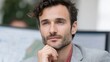 © BOJOShop - A thoughtful businessman with stubble and a grey jacket ponders in an office setting