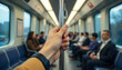 © Umair - hand of Commuter holding handrail inside BTS sky train during transit with seated passengers, created with generative ai