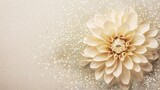 Cream paper dahlia flower with delicate petal layers placed on a glittery background, featuring soft neutral tones and sparkling texture, suitable for wedding invitations, greeting cards,
