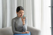 © Charlie's - Asian woman using voice assistant on smartphone at home conversation with online assistant Voice chat bot conversational AI Modern Technologies.