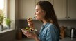 © onehourhappiness - Woman Enjoying Healthy Salad in Kitchen