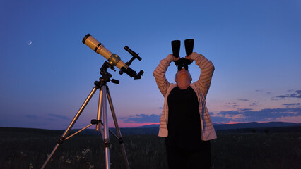 Wall Mural - amateur astronomer using telescope and binoculars for watching stars, moon, planets and other celest