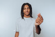 © bodnarphoto - portrait of young man looks playfully at the camera while forming a heart shape with his fingers, radiating warmth and affection on light background