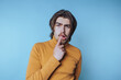 © bodnarphoto - portrait of young man with a thoughtful expression poses on blue background