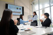 © crizzystudio - Businesswomen shaking hands while colleagues are clapping in the office meeting room