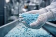 © dave - Gloved hands feeding blue plastic granules into automated production line in modern factory, showcasing industrial manufacturing and material processing technology