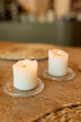 © Alena - Two white candles on glass holders with a blurred background in a cozy setting