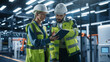 © Gorodenkoff - Two Diverse Engineers Walking, Using Tablet Computer at an Industrial Machinery Factory. Caucasian Female and Hispanic Male Specialists Chatting and Monitoring Robots on a Modern Assembly Line.