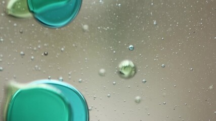 Wall Mural - Close-up of blue and green liquid with floating bubbles and blobs in motion inside a lava lamp, viewed in a horizontal orientation. Hypnotic and abstract visual texture.