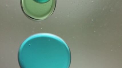Wall Mural - Close-up of blue and green liquid with floating bubbles and blobs in motion inside a lava lamp, viewed in a horizontal orientation. Hypnotic and abstract visual texture.