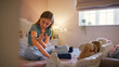© Monkey Business - Young Diabetic Girl Sitting On Bed In Bedroom At Home Using Kit To Measure And Check Insulin Levels