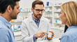 © gle - Pharmacist man showing medicine to a man and woman. Pharmaceutical consultation and healthcare support in a pharmacy setting.