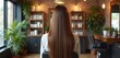 © Pete - Back view of lady with long shiny hair in salon chair. Elegant interior with plants and brick wall. Focus on healthy hair care and beauty treatments for a luxurious salon experience.