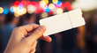 © Asmarajun - Hand holding a blank ticket against bokeh background