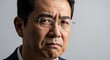 © Rafaela - Concerned Asian Businessman: A middle-aged Asian man, wearing glasses and a suit, displays a look of deep concern and worry, his brow furrowed with unease.