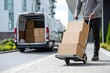 © glen - Delivery worker transporting boxes with hand truck outside apartment building