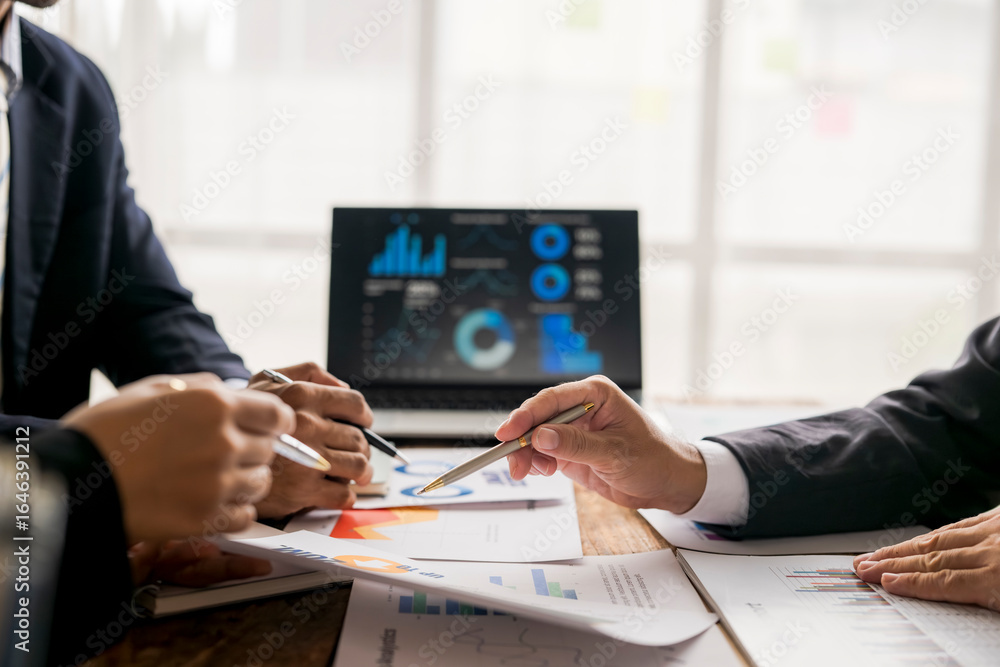Business people analyzing financial charts and graphs on laptop and ...