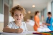© The Little Hut - Smiling Young Boy Drawing with Crayons in Hospital Waiting Room, Hopeful Child Patient