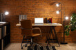 © Pixel-Shot - Interior of dark office with workplace, blank laptop and glowing lamps at night