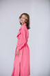 © kuzmichstudio - The model is a young beautiful girl in a pink dress in a studio on a white background