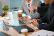 © Prathankarnpap - Close up of business professionals collaborating on a laptop during a meeting
