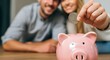© ismail - Happy couple saving money together placing a coin into a pink piggy bank investment future planning concept focused financial security