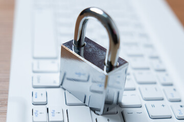 Wall Mural - Silver padlock on a white keyboard. Digital security, data protection, and online safety concept.