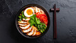 © Ari Wibowo - Overhead view of spicy tantanmen ramen in black bowl looks strong