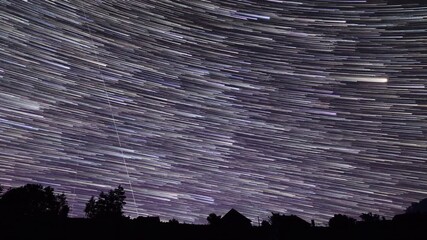 Wall Mural - milky way star-trails and rural countryside tree silhouettes. time-lapse video.