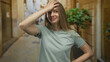 © Krakenimages.com - Young woman with long hair smiling and touching forehead on a city street outdoor setting, capturing a moment of relief and amusement in a casual urban environment.