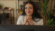 © Krakenimages.com - Woman working in a modern office setting with plants and shelves, looking thoughtful and smiling, interior has a relaxed ambiance featuring organized workspace.