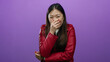 © Krakenimages.com - Woman laughing wearing red jacket with hand over mouth against isolated purple background showing cheerful emotion attractive fashion.