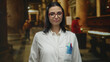 © Krakenimages.com - Woman in a white uniform, with red glasses, presenting inside a historic church background, highlighting science and heritage.