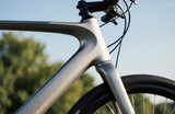 A close-up of a modern bicycle frame with a blurred outdoor background