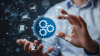 Person holding digital interface with gears and icons representing business and technology concepts
