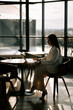 © Darius - Businesswoman working on laptop in modern cafe during afternoon sunshine