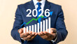 © Muh - Businessman presenting a positive financial forecast for 2026 with rising growth chart