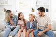 © New Africa - Happy family sitting on sofa at home