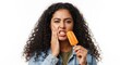© Pro DG Collections - Woman with curly hair holding orange popsicle and grimacing while touching her cheek in pain