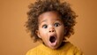 © JoxyAimages - An expressive toddler with big eyes and curly hair exclaims in surprise, radiating innocence and curiosity while against a warm-toned background, encapsulating childhood wonder.