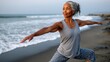 © Artsaba Family - A healthy senior woman practices yoga on a beach, enjoying serenity and wellness