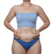 © New Africa - Liposuction. Woman in underwear touching her belly on white background, closeup
