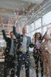 © Ilia - Blurred background of people in business suits celebrating in an office, throwing confetti and holding party streamers. Concept of corporate celebration, team success, and joyful workplace moments.