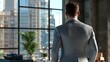 © Mary - Businessman gazes at city skyline from modern office in late afternoon light